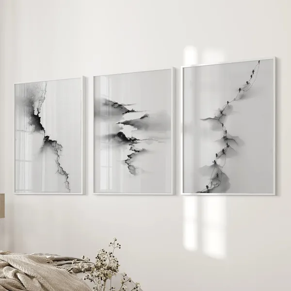 Three framed black-and-white ink paintings above a bed